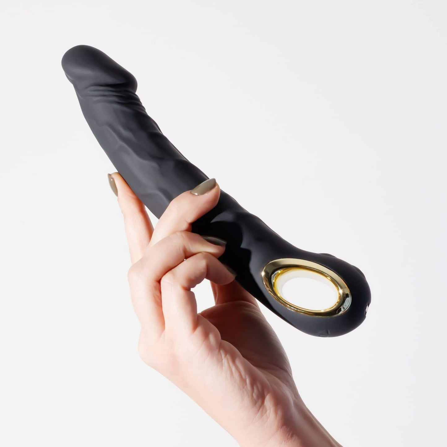 Vibrador Magnus realista con 10 modos, sostenido con una mano.