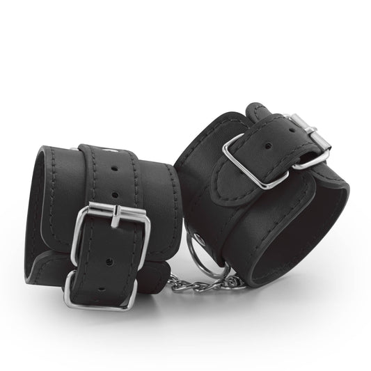 Esposas de cuero vegano negras, ajustables con cadena desmontable y anillos metálicos para juegos de bondage.